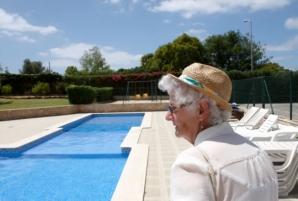 Une dame âgée au bord de la piscine extérieure — Photo