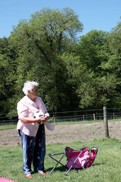 Старшая леди держит мяч — стоковое фото