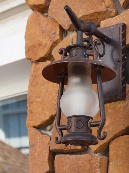 stock image Old-fashion lamp hanging on sand stone wall