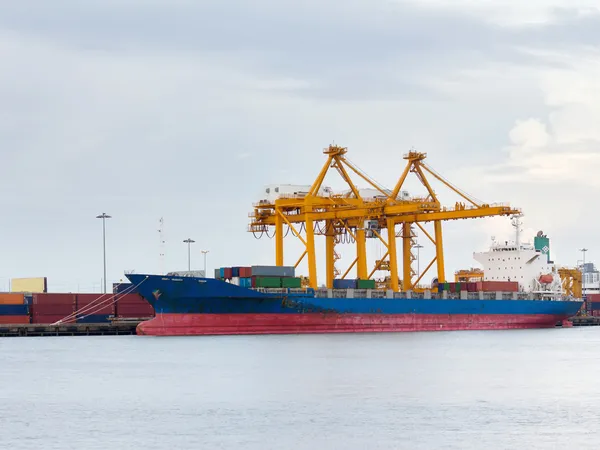 stock image Port of container cargo freight ship with working crane bridge