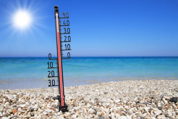 Termómetro en una playa muestra altas temperaturas — Foto de Stock