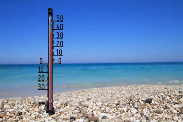Termômetro em uma praia mostra altas temperaturas — Fotografia de Stock