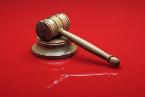 Domarens ordförandeklubban på röd bakgrund — Stockfoto