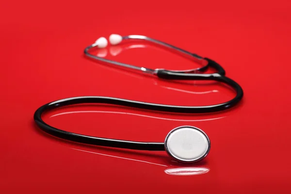 Kırmızı zemin üzerine stetoskop — Stok fotoğraf