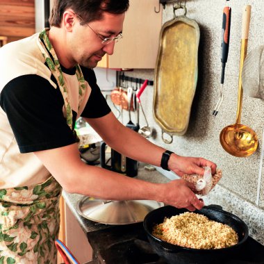 Man cooking at his kitchen eastern cuisine clipart