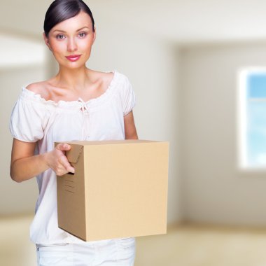 Smiling woman at her home holding boxes. She is Moving at her ne clipart