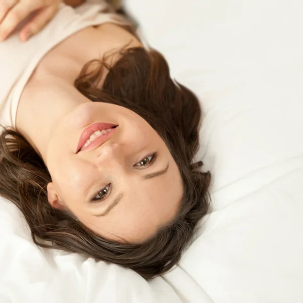Schöne junge schlanke Frau auf dem Bett drinnen Auspacken von Kleidung — Stockfoto