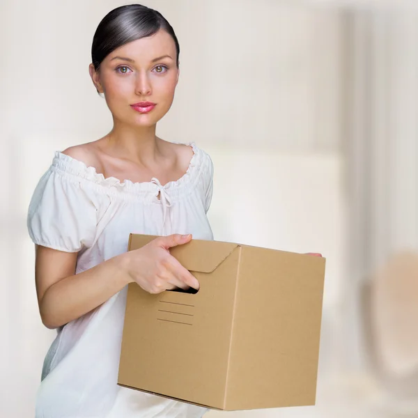Smiling woman at her home holding boxes. She is Moving at her ne — Stock Photo, Image