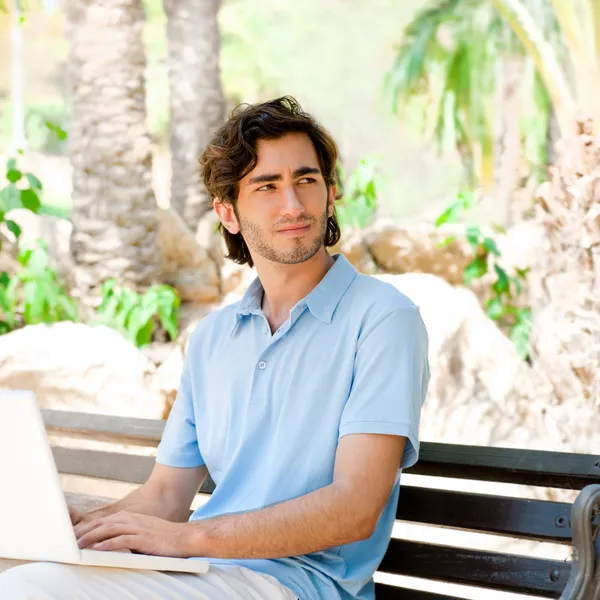 Laptop szabadtéri ül a padon egy fiatal férfi portréja — Stock Fotó