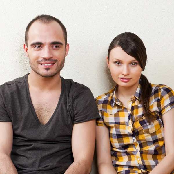 Attraente giovane coppia di adulti seduto vicino sul pavimento in casa smi — Foto Stock