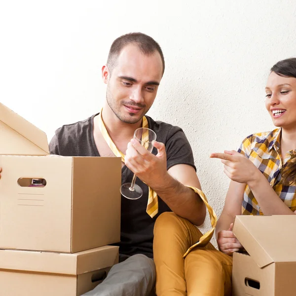 Fiatal pár doboz, az új lakásban ülő földre egy — Stock Fotó