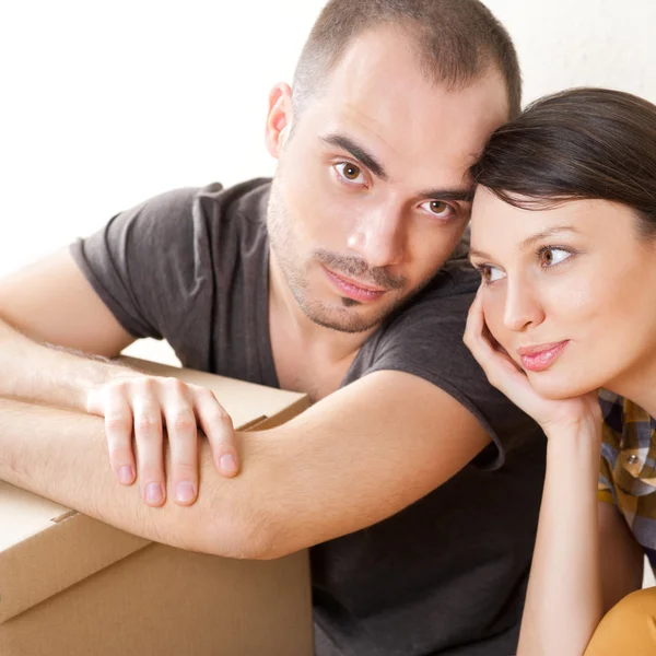 Молодая пара с коробками в новой квартире сидит на полу — стоковое фото