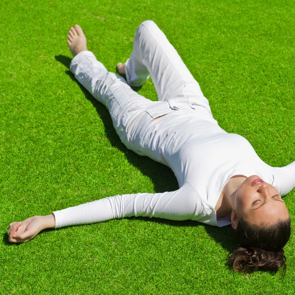 Fullängds vacker kvinna på gräset i vita kläder — Stockfoto