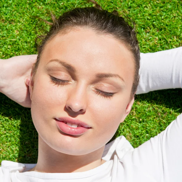 Joven hermosa mujer en la hierba con los ojos cerrados —  Fotos de Stock