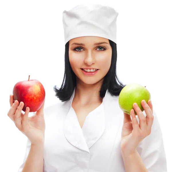 A female medical doctor holding a red and green apples in differ Royalty Free Stock Images