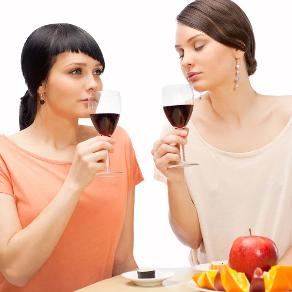 Χαρούμενα γυναίκες τρώγοντας φρούτα και πίνοντας κόκκινο κρασί — Φωτογραφία Αρχείου