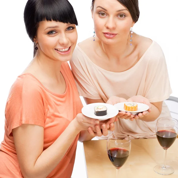 Χαρούμενα γυναίκες τρώγοντας σούσι κυλίνδρους και πίνοντας κόκκινο κρασί — Φωτογραφία Αρχείου