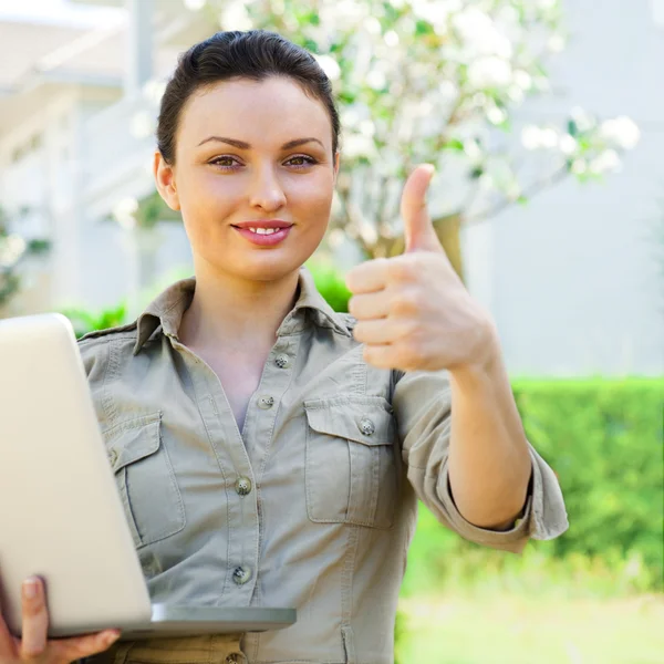 Jeune jolie agent immobilier féminin avec ordinateur portable présentant beautifu — Photo
