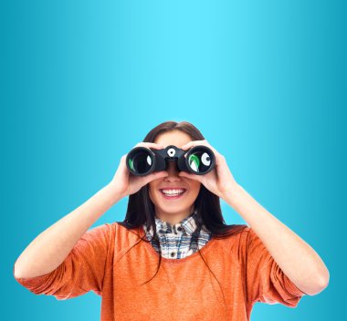 Woman looking through binoculars isolated on blue