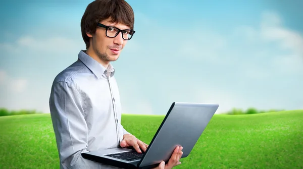 Portret van een jonge man met laptop buiten op het platteland — Stockfoto