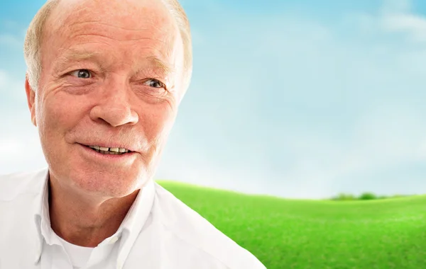 Portrait of a happy senior man smiling over bright background — Stock Photo, Image