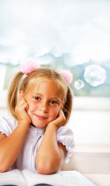 Portrait of a young girl in school at the desk. Vertical Shot. D clipart