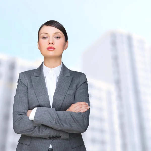 Kendinden emin bir iş kadını modern binanın önünde duran — Stok fotoğraf
