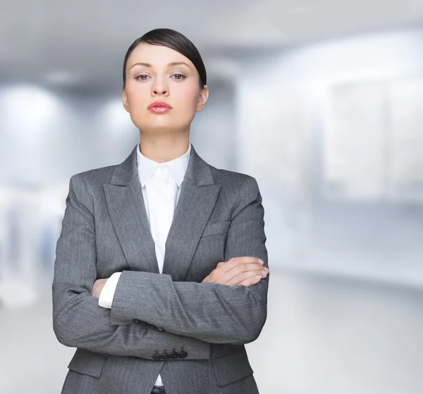 Confident business woman. Standing with hands folded at her offi — Stock Photo, Image