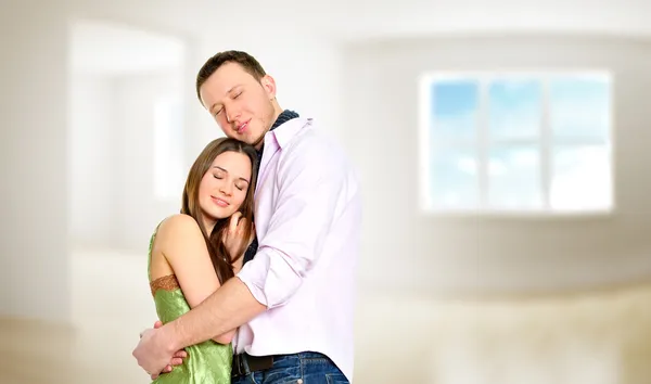 Acogedora pareja joven abrazando el interior de un nuevo apartamento y la planificación de —  Fotos de Stock