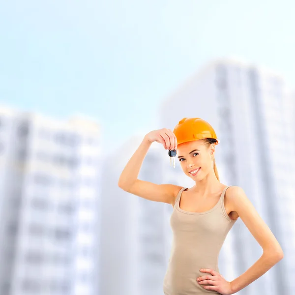 Mooie vrouw presenteert nieuwe appartement in moderne woningbouw. — Stockfoto