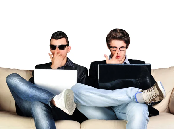 Two young gamers sitting together on sofa and using their laptop — Stock Photo, Image