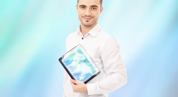 Чоловік показує екран планшетного комп'ютера, посміхаючись на синьому цифровому зворотному боці — стокове фото