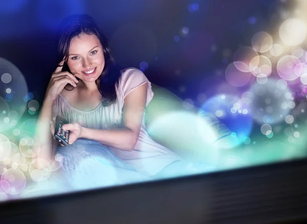 Ung kvinna tittar på tv som sitter på beanbag hemma — Stockfoto