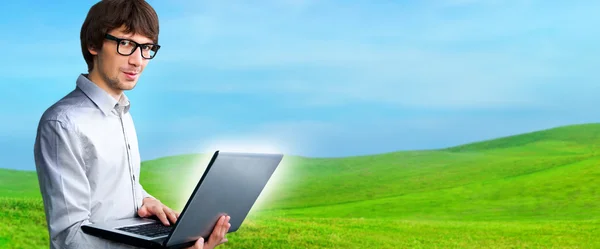 Retrato de um jovem com laptop ao ar livre no campo — Fotografia de Stock