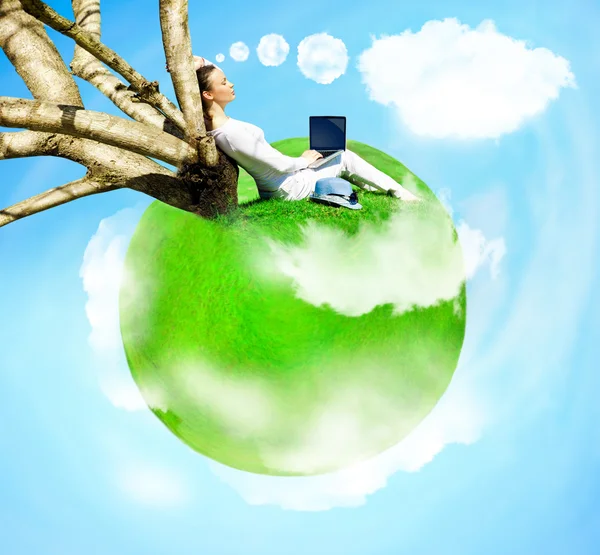 Mujer joven sentada bajo el árbol en su propio pequeño planeta volando en —  Fotos de Stock