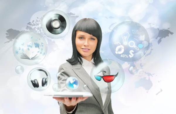Mujer de negocios bastante sosteniendo tableta ordenador y diferentes objetos están volando desde la pantalla táctil — Foto de Stock