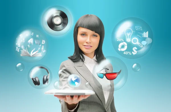 Mujer de negocios bastante sosteniendo tableta ordenador y diferentes objetos están volando desde la pantalla táctil —  Fotos de Stock