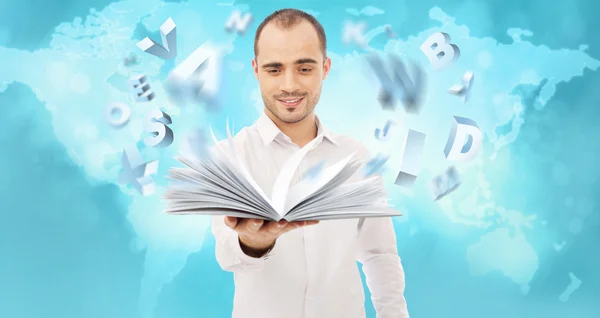 Adult man holding an opened book and reading. Letters are flying — Stock Photo, Image
