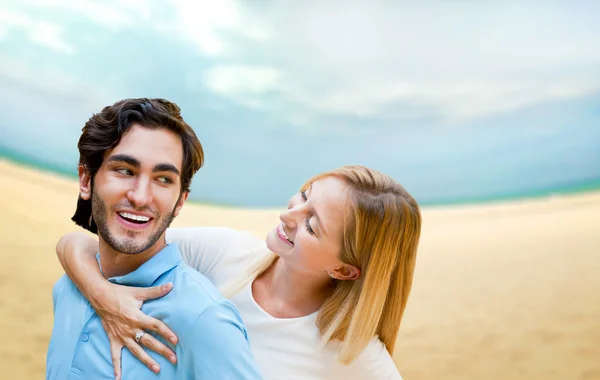 Портрет влюбленной молодой пары, обнимающейся на пляже и наслаждающейся — стоковое фото