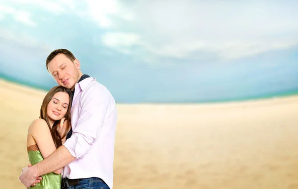 ビーチで抱き合うことで愛の若いカップルの肖像画 — ストック写真
