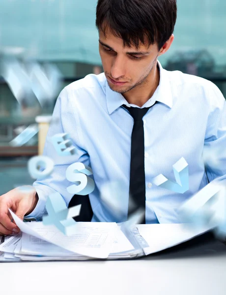 Взрослый бизнесмен читает и подписывает документы в своем офисе — стоковое фото