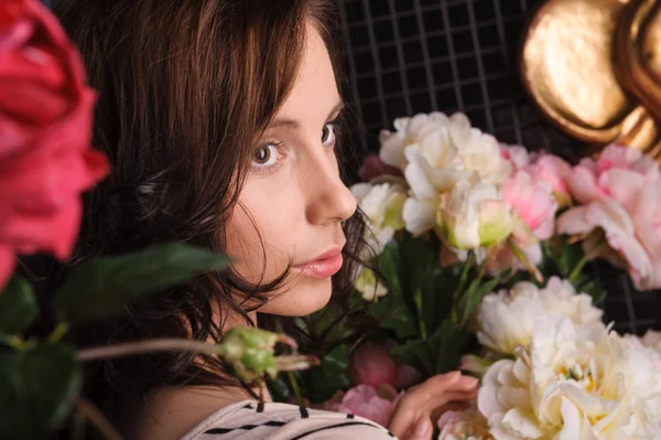 Retrato de mujer joven y hermosa con flores en habitación oscura con —  Fotos de Stock