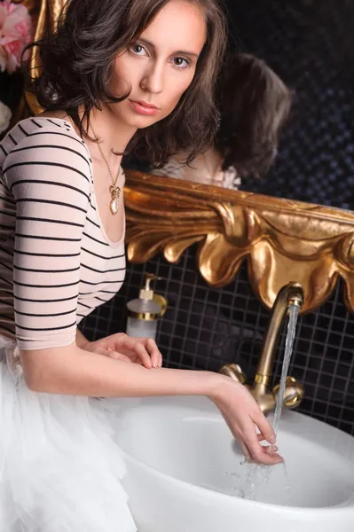 Unga vackra kvinnan tvätta händerna på lyxiga inredning badrum — Stockfoto