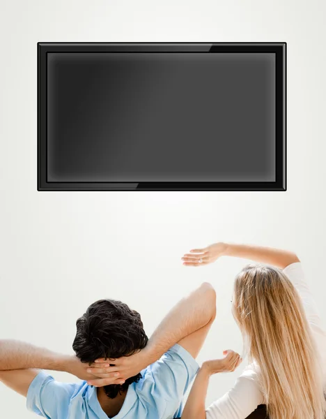 Young couple watching tv. Photo from behind. Lots of copyspace — Stock Photo, Image