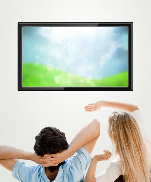 Young couple watching tv. Photo from behind. Lots of copyspace — Stock Photo, Image