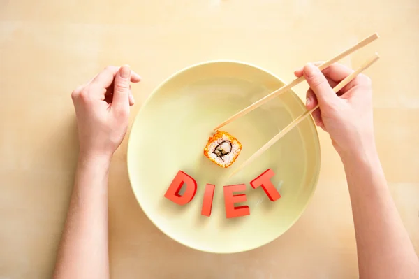 Woman holding sushi with chopsticks top view. Diet sign designed — Stock Photo, Image