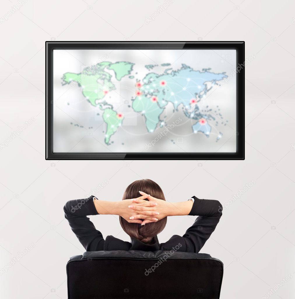 Woman watching tv. Photo from behind. Worldmap at the screen
