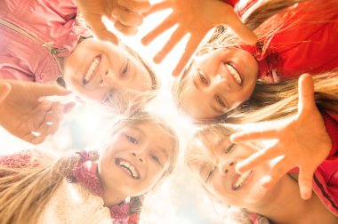 Young girls are bending to camera from above and showing their a clipart