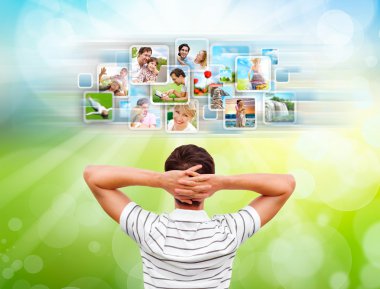 Young man standing in front of virtual preview of different imag