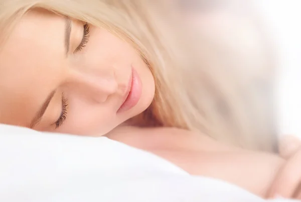 Closeup portrait of a cute young woman sleeping on the bed — Stock Photo, Image